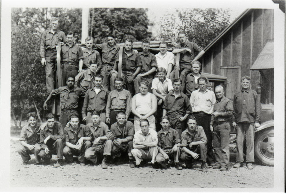 Archival image of a group of 26 men posing on a car