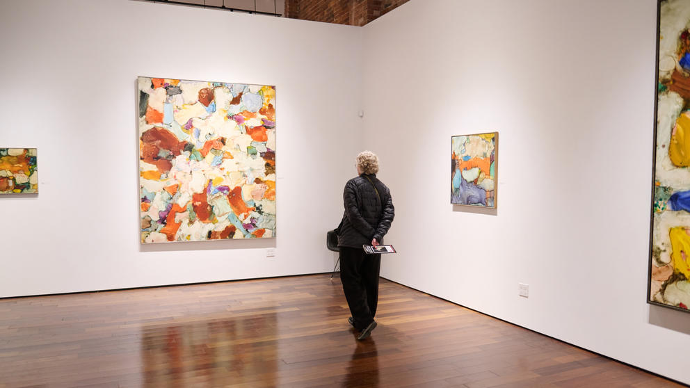 A person looking at a painting in a gallery