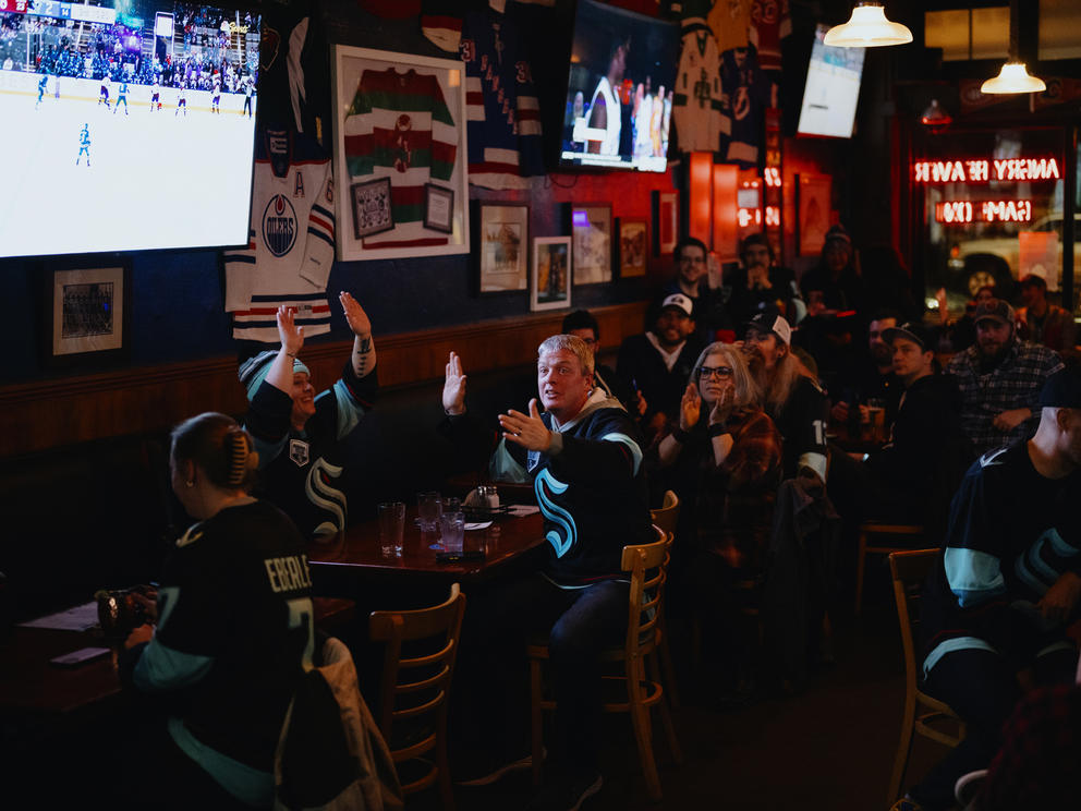 Fans clap and react to a goal in a sports bar