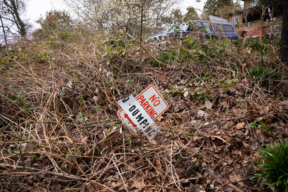 A “no dumping” sign that Roger Kelley unearthed in his overgrown lot near his home