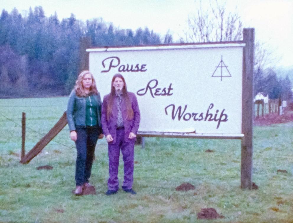 a vintage looking photo of a man and woman in front of a highway chapel sign