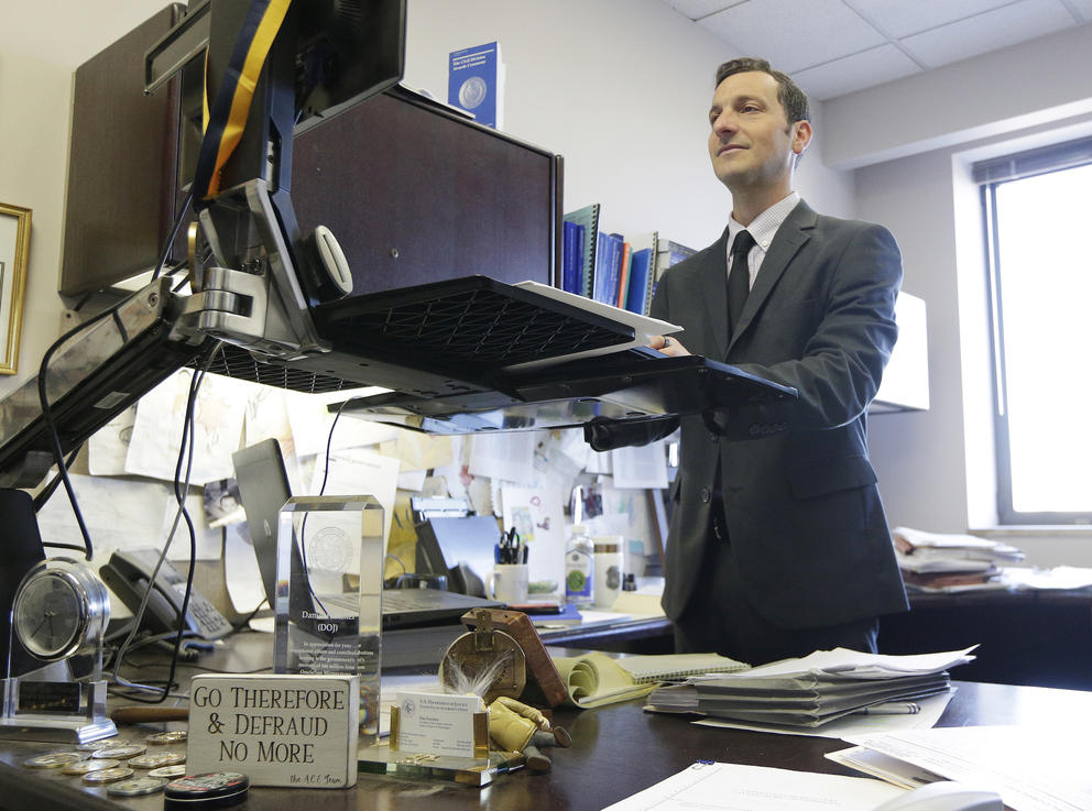 Fruchter stands at an adjustable-height desk, typing on his computer.