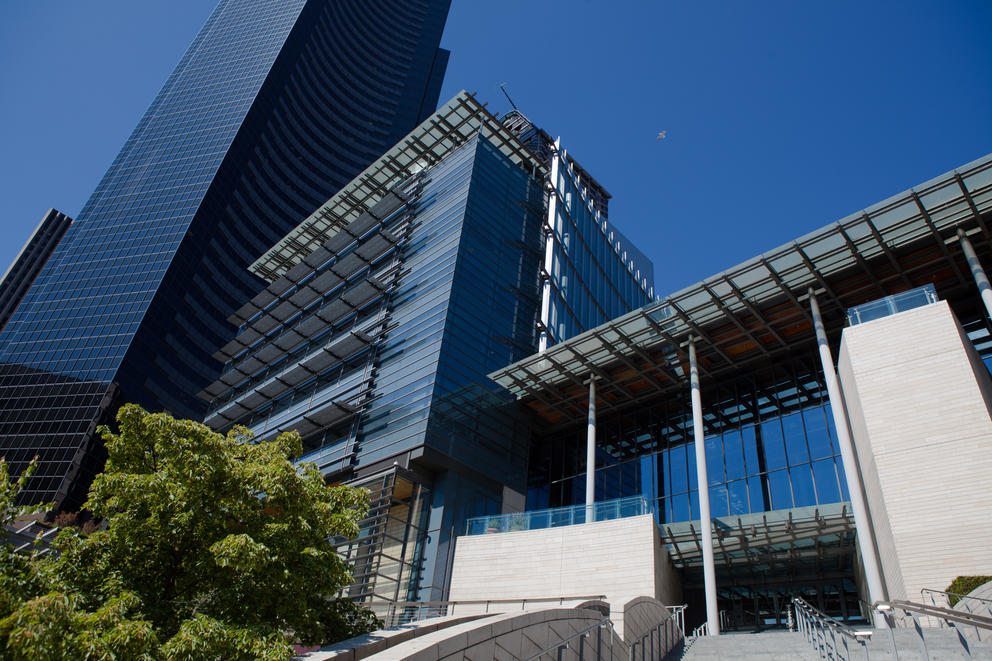 the outside of seattle city hall, with a glass office tower looming in the background