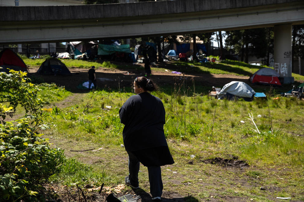 Family and friends of Shaulina Bulltail walk around a homeless encampment