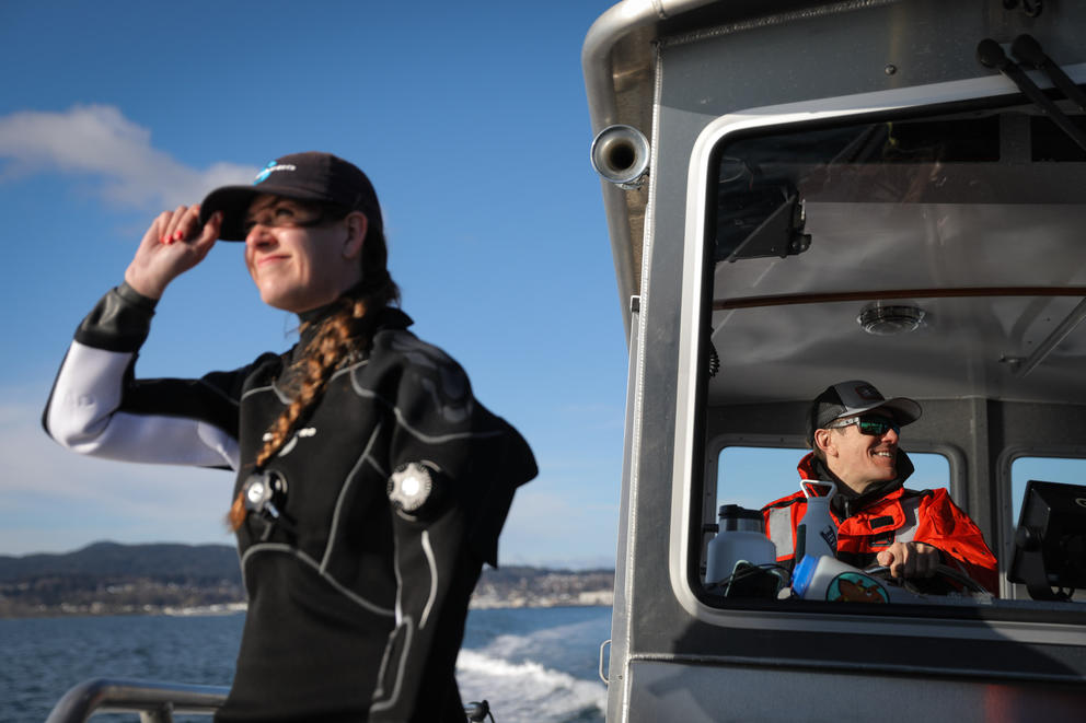 Dive lead Jennie De La Cruz, left, looks out from the boat as DNR manager Matt Castle captains it