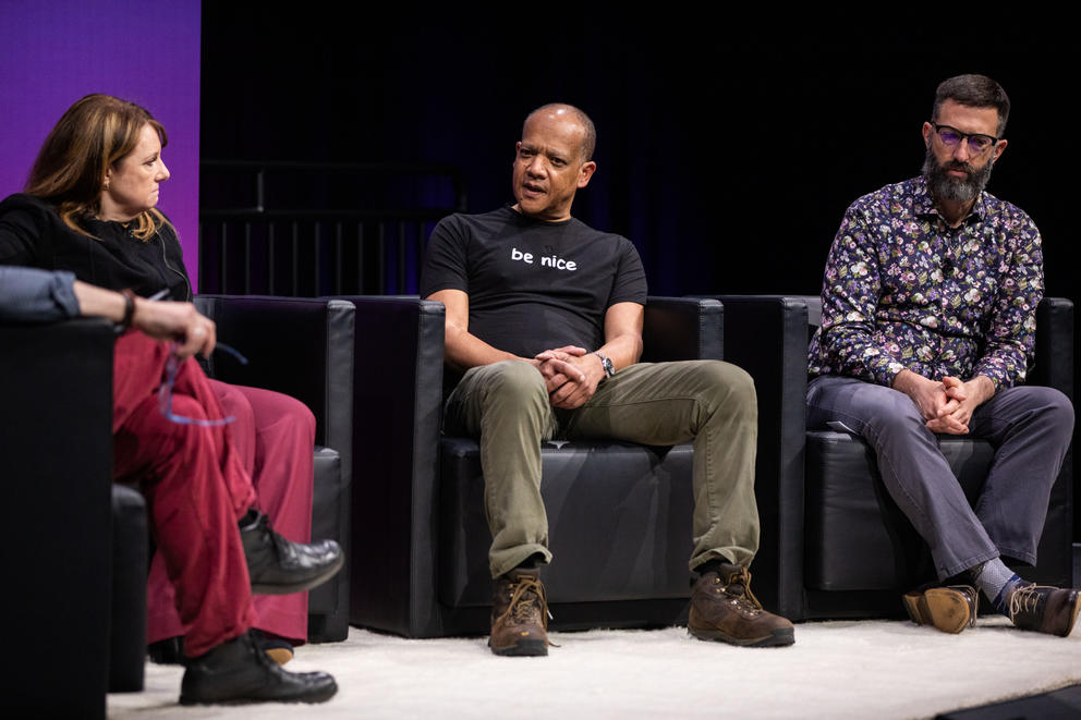 Three people sitting on a stage conversing