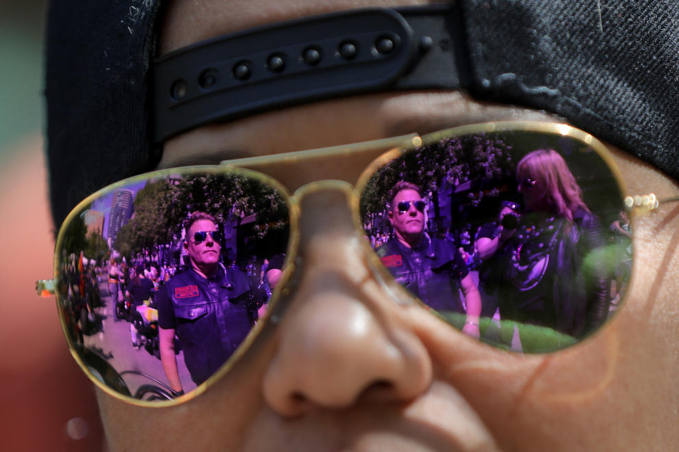 A close up of a person reflected in purple aviator sunglasses