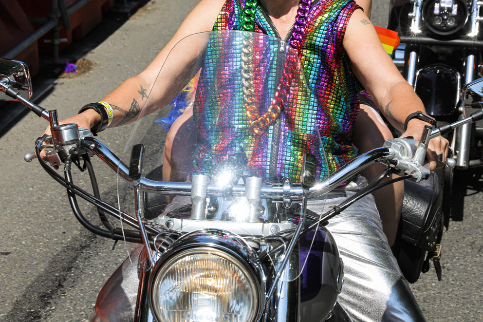 A close up from the shoulders down of a rider wearing colorful clothing