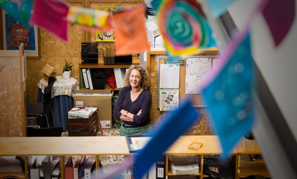 Stacey Marron smiles behind strings of handmade flags and banners