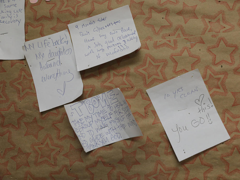 a close up of hand written notes pinned to a cork board