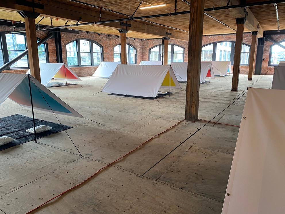 a big open room filled with white pup tents