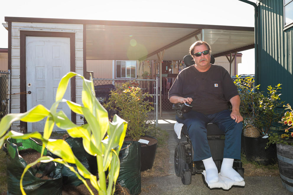 A man in a wheelchair in his backyard