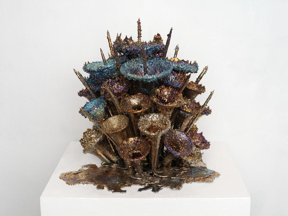 a sculpture made of a bouquet of upturned horns, covered in a chunky metallic coating