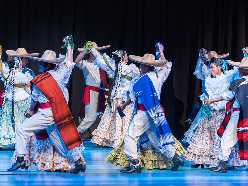 photo of many dancers on stage performing traditional Mexican dance
