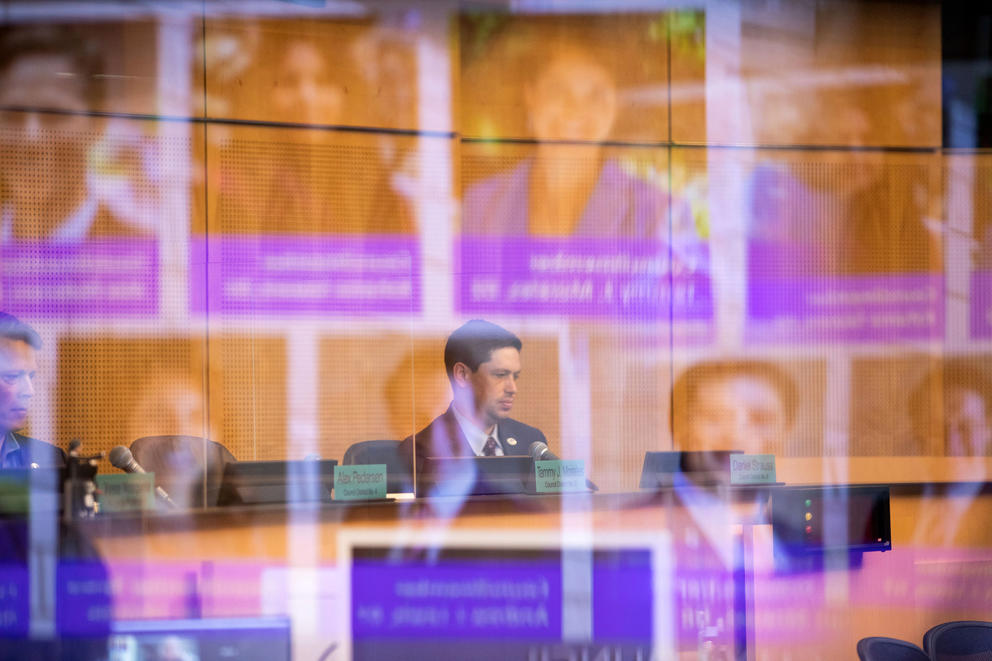 images of seattle city council members reflect off of plexiglass