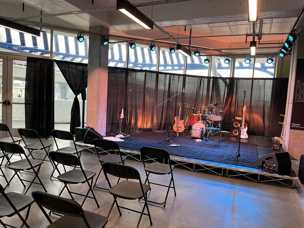 A stage with instruments on it; folding chairs sit in front of it