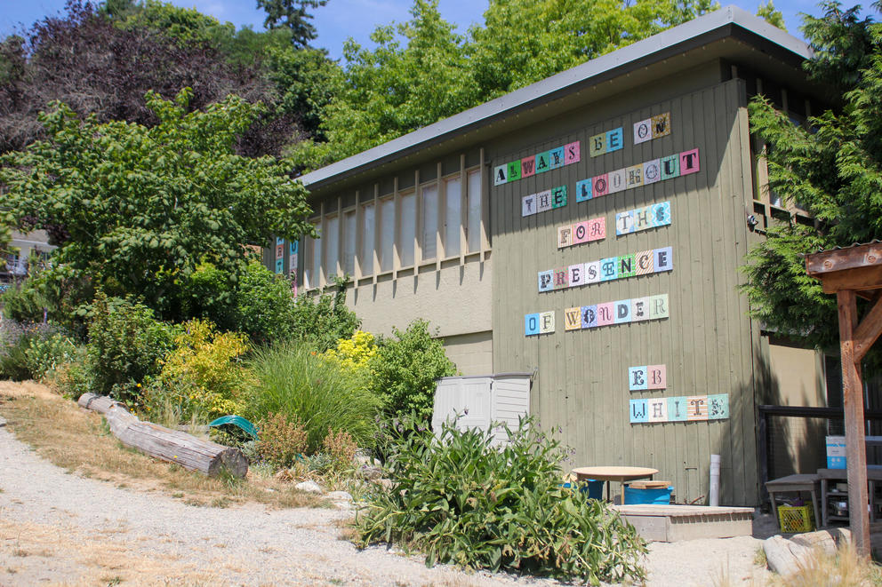 A building on a hillside has a mural with the words, "Always be on the lookout for the presence of wonder. -- E.B. White." 