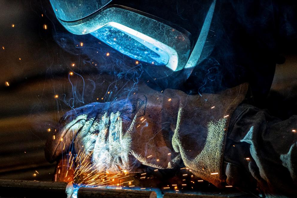 Up-close shot of a worker in PPE welding