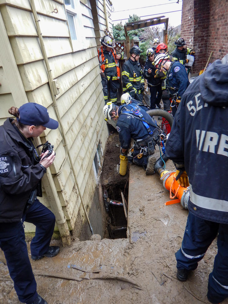 More than half a dozen emergency workers surround a trench that had collapse.