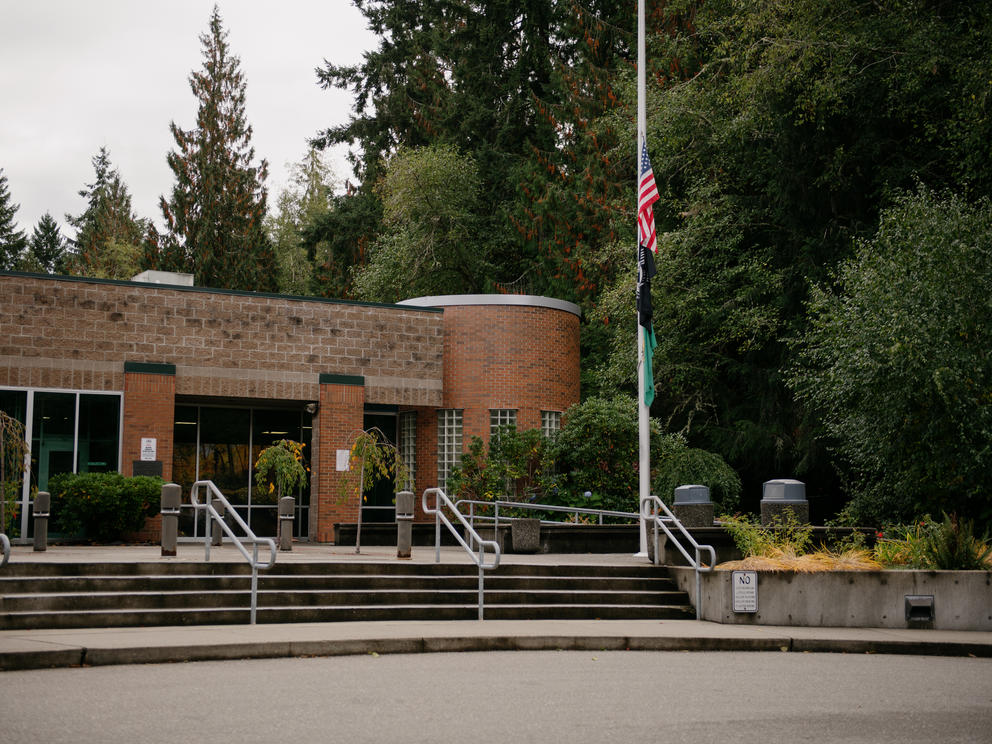 The red brick Kitsap County juvenile court next to a stand of evergreen trees.