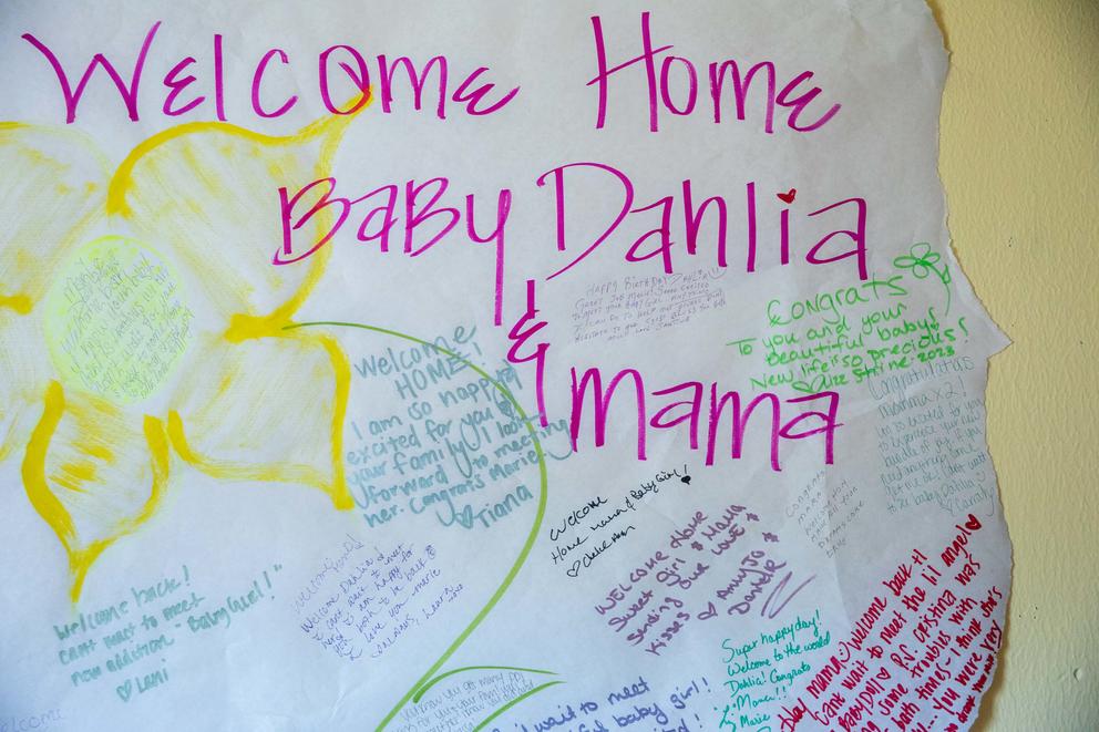 A close up of a sign reading Welcome Home Baby Dahlia & Mama with messages written on it