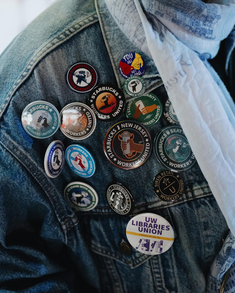 A close up of Starbucks union buttons on a denim jacket