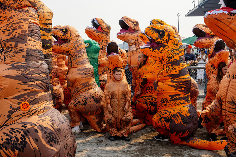 A group of people dressed in Tyrannosaurus Rex dinosaur costumes