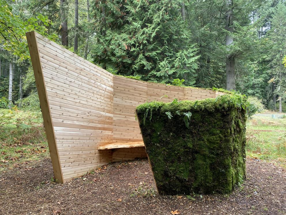 Angular wood and mossy rock outdoor sculpture 