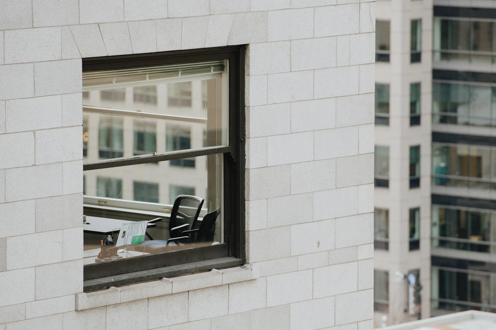 a closeup of a window with an empty office chair in it