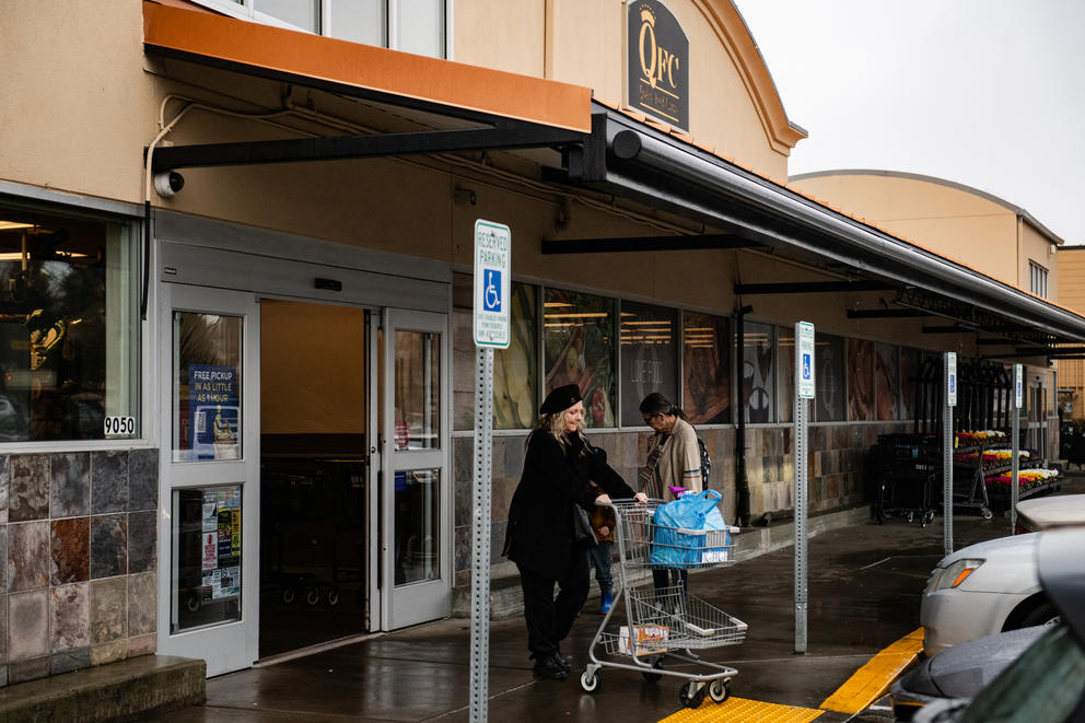 Customers come and go at the entrance to a QFC grocery store in Seattle.