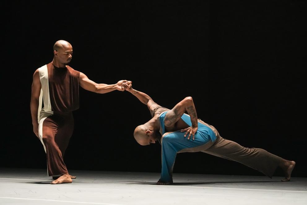 two Black dancers on stage in an emotive dance performance