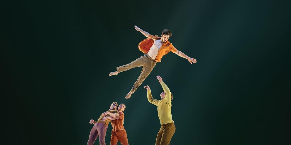 photo of acrobats flying through the air onstage