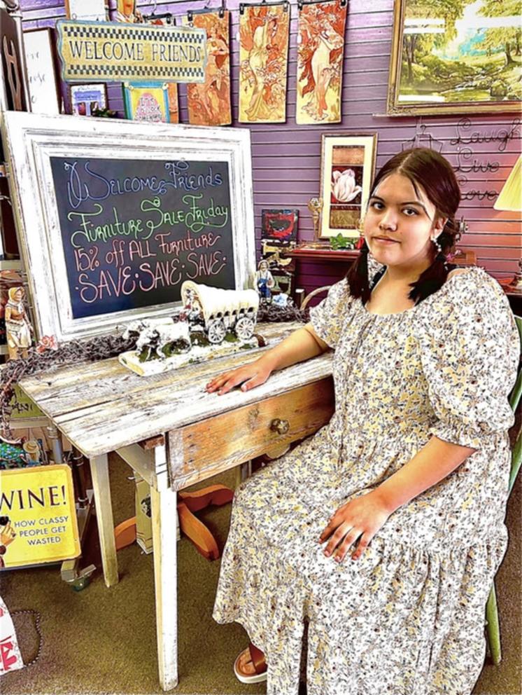 Kit Nelson-Mora sells furniture at their mom’s thrift store, The Storehouse Merchantile, in Omak, Wash., in the summer of 2021. 