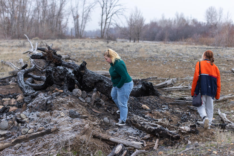 Amythist McCart, left, and Kayla Shelton walk around the charred remnants of a spot and Kit Mora would frequent in their youth.