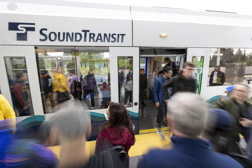 People crowd onto a train that says "Sound Transit" on the door.