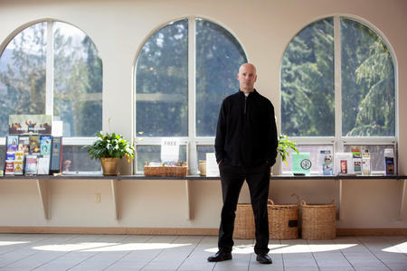Father Todd Strange stands in front of windows