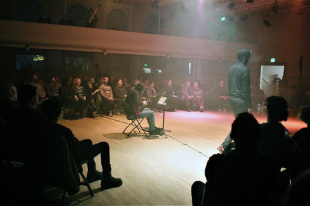 A musician performs on stage at Washington Hall
