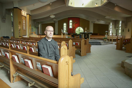 Father Todd Strange sits in the pews of St. Joseph Catholic Church in Issaquah.