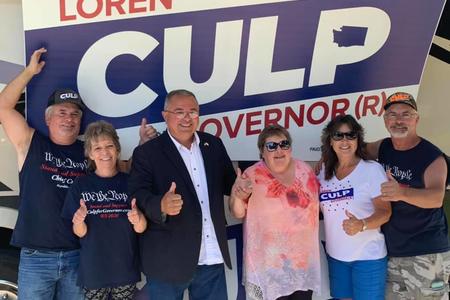 Loren Culp and four supporters stand in front of one of his campaign signs