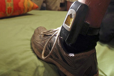 A person wears an ankle monitor