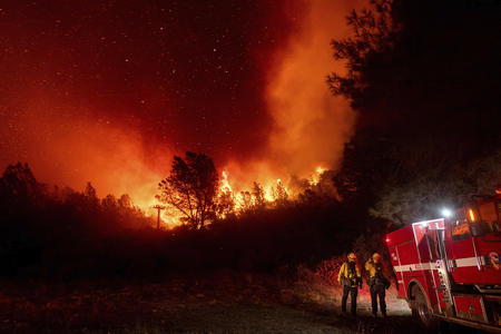 Firefighters observe a wildfire