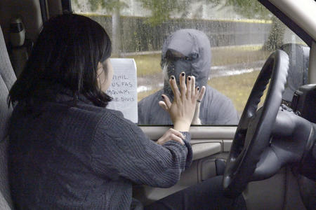 A person in a car puts their hand on the window, another person stands outside