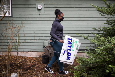 Jamila Taylor carries campaign signs 
