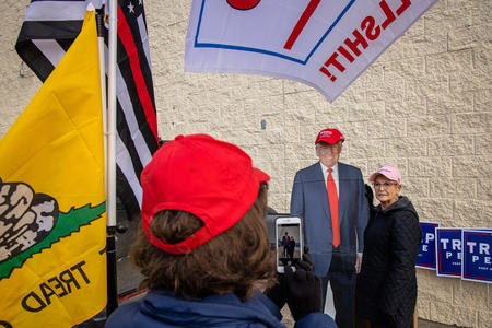 A woman poses with a cardboard cutout of Trump