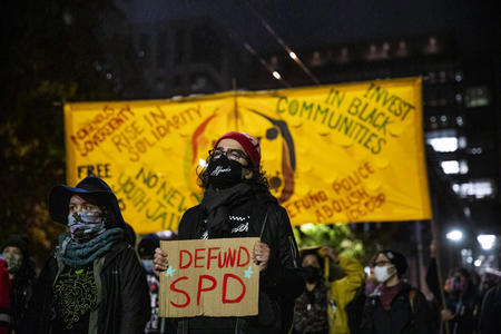 Activist marching with “DEFUND SPD” sign