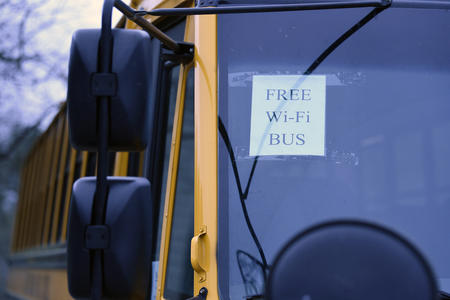 a sign hangs in a parked school bus: "wifi available here"