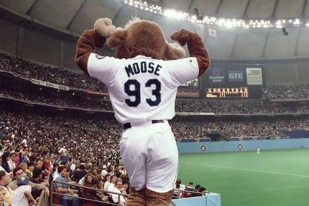 A mascot from behind with a white jersey saying "Moose"