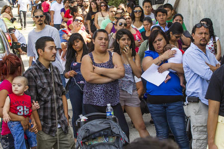 FILE - In this Aug. 15, 2012, file photo, a line of people living in the U.S. without legal permission wait outside the Coalition for Humane Immigrant Rights in Los Angeles. Washington state is joining California and others in suing the Trump administration over its decision to add a question about citizenship to the 2020 U.S. Census. (AP Photo/Damian Dovarganes, File)