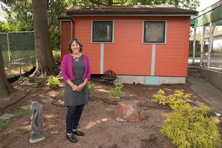 Architect Sheri Newbold stands outside her cottage in Seattle's Greenwood neighborhood, June 1, 2018. 