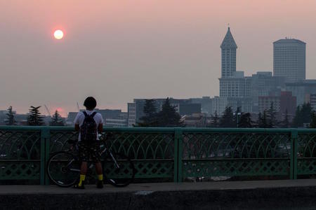 A man stops to look at a smoky sunset in Seattle